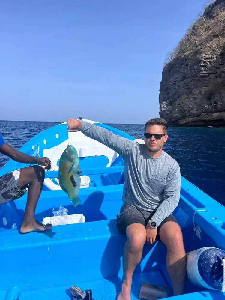 Guest riding in the company boat by the St. Lucia cliffs
